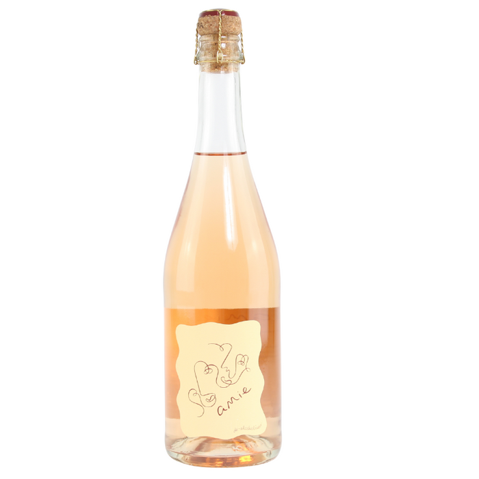 A bottle of Amie de-alcoholised Sparkling Rose wine with a pink hue visible through the glass, featuring a simple, elegant label.